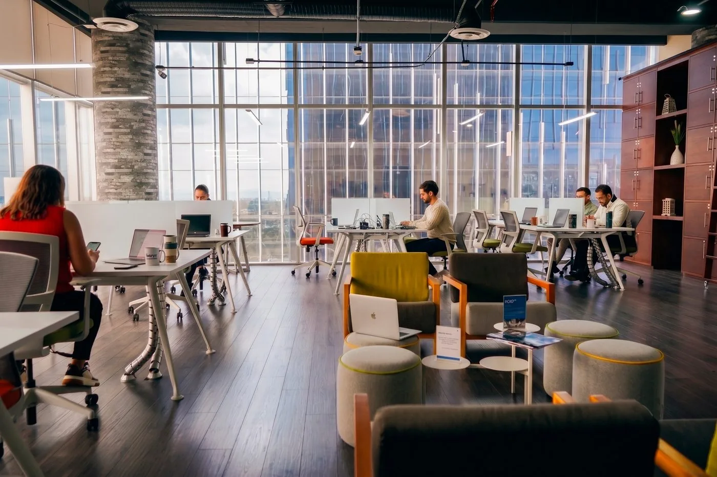 Área de coworking de GPD Antea con ventanales de piso a techo y personas trabajando, Querétaro