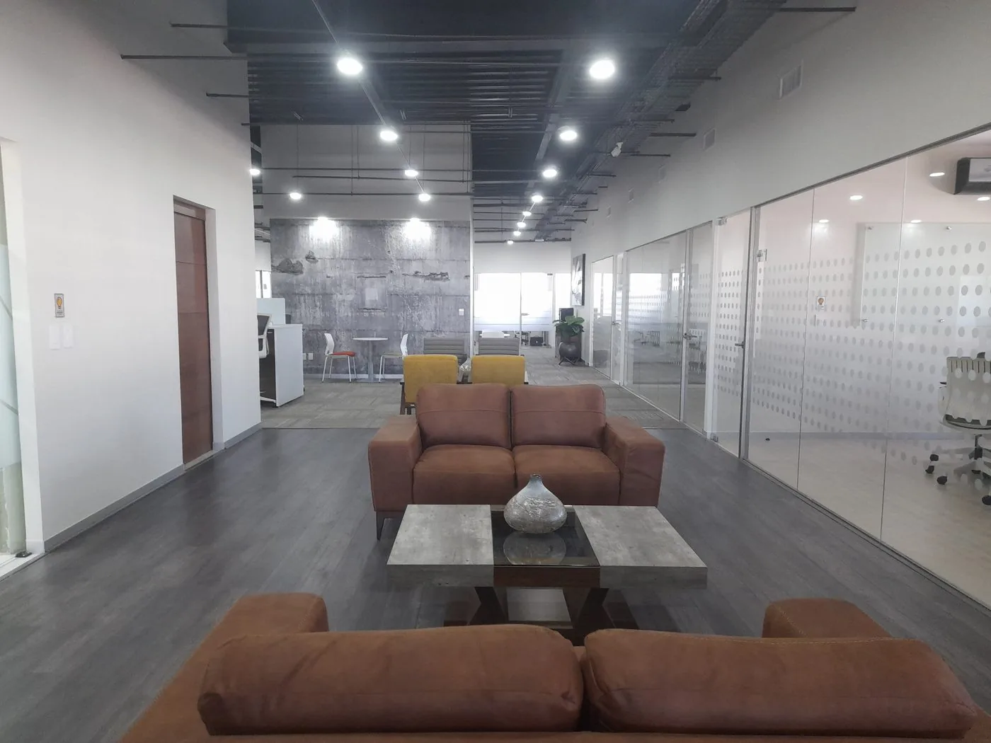 Áreas comunes de GPD El Refugio con sillones y oficinas privadas al fondo, Querétaro